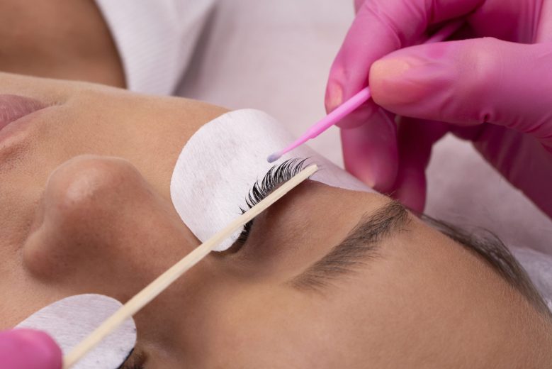 high-angle-hand-holding-pink-swab